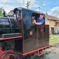 František Krumpolec steht im Führerhaus einer historischen Dampflokomotive und blickt lächelnd aus dem Fenster.