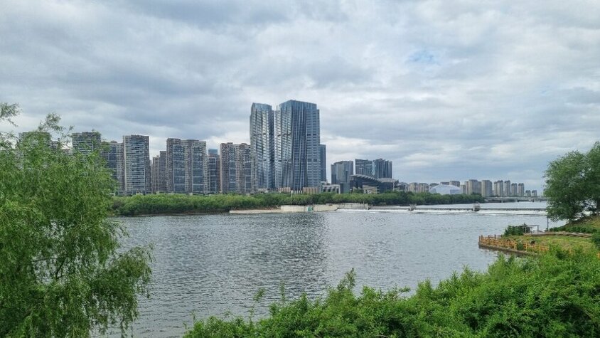 Blick über einen breiten Fluss auf eine moderne Skyline mit Hochhäusern in China – ein Eindruck aus Jan Wengryns Zeit im Auslandseinsatz.