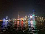 Nächtlicher Blick auf die beleuchtete Skyline von Shanghai mit farbig reflektierenden Lichtern auf dem Wasser – ein Highlight aus Jan Wengryns Zeit in China.